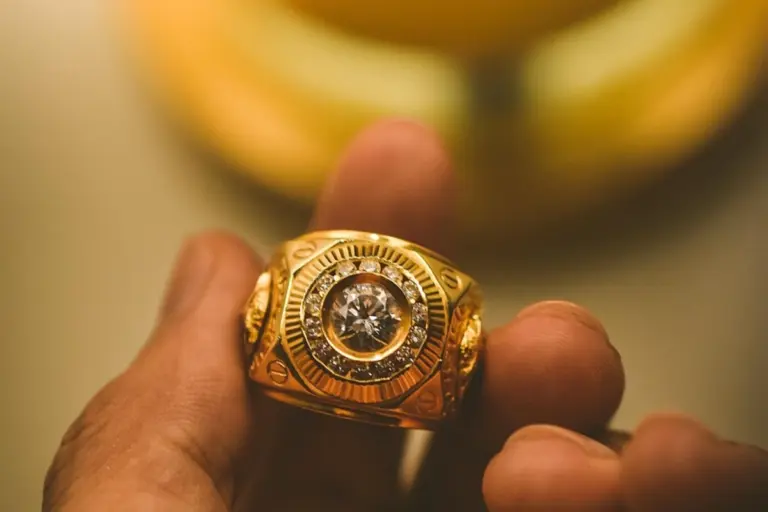 Mano sujetando un anillo de oro entre los dedos