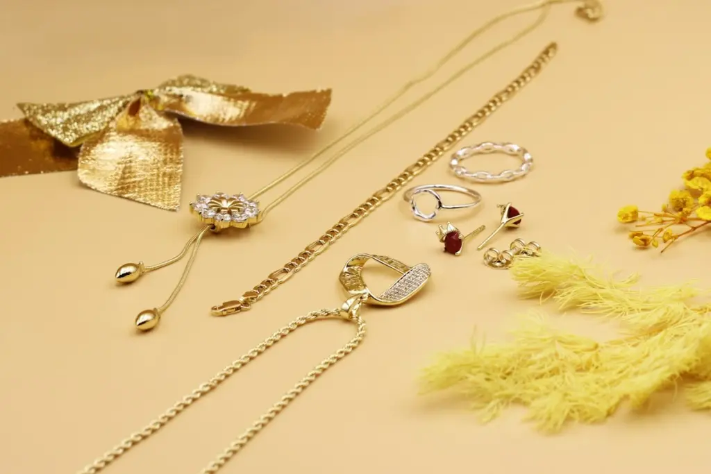 Cadenas y colgantes de oro junto a anillos de plata sobre una mesa