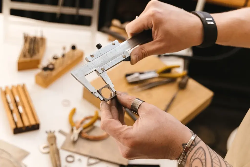 Joyero midiendo un anillo con un calibre en su taller